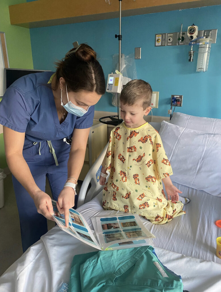 Ally Kennedy working with pediatric patient in his hospital bed.