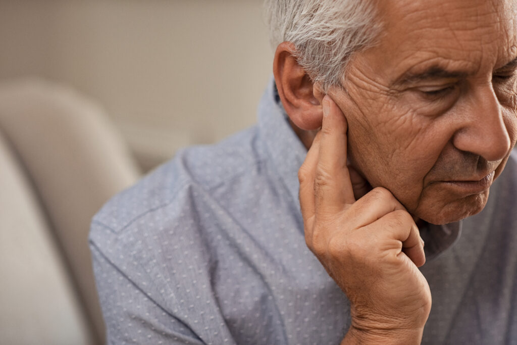 Side view of senior man with symptom of hearing loss