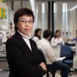Dong Feng Chen poses in front of her research team in her lab at the Schepens Eye Research Institute of Mass Eye and Ear in Boston.