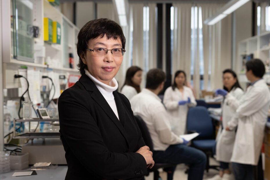 Dong Feng Chen poses in front of her research team in her lab at the Schepens Eye Research Institute of Mass Eye and Ear in Boston.