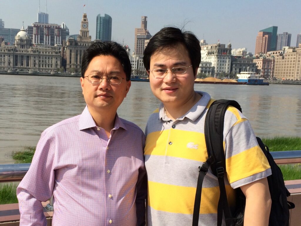 Zheng-Yi Chen, DPhil (left) and Yilai Shu, MD (right) are photographed outside on a bridge in this file photo from an earlier visit to China.