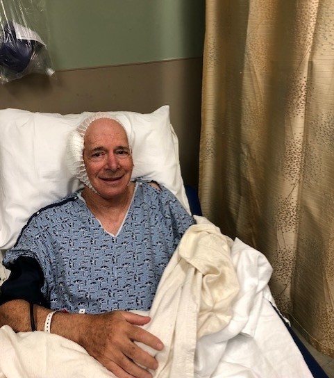 Mark photographed in a hospital bed with his head bandaged during his care at Mass Eye and Ear.